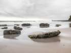 Rocks on a sandy beach Art Print