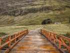 Wooden bridge over water stream at Glen Coe valley, Scotland Art Print
