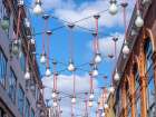 Light bulbs hanging across the buildings for Christmas decorations, London Art Print