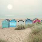 Beach huts on sandy seashore Art Print