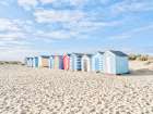 Beach huts on sandy seashore Art Print