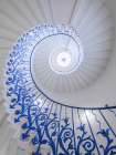 Looking up at spiral staircase with Blue railing Art Print