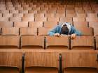 Alone Student Sleeps On Desk In Empty Lecture Hall With Wooden Seats. Germany Art Print