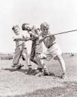 1930S 1940S Three Smiling Energetic Teen Boys Struggling Together Pulling Rope In Tug Of Sneakers Art Print