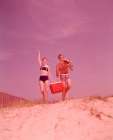 1960S Beach Couple Walking In Sand Carrying Cooler Woman Waving Art Print