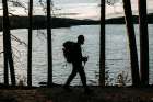 A Male Walker With A Backpack Hikes Along The Edge Of A Lake In Maine Art Print