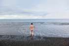 A Young Man Steps Naked Into The Frigid Waters Of Adventfjorden Outside Longyearbyen, Svalbard. Art Print