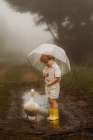 Little Boy In The Rain Hodling A Umbrella Witha White Duck Art Print