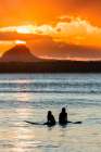 Two Surfers Wait For A Wave At Sunset. Art Print