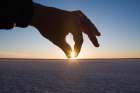 A Hand Pinches The Setting Sun Over The Salt Flats On Laguna San Ignacio, Baja California, Mexico. Art Print