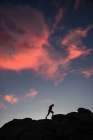 Adventurer Scaling Rocky Cliff At Sunset: Embrace The Journey Into Natures Beauty Art Print