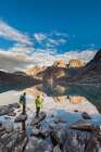 Hikers View East And West Maiden And Camel Peaks As They Reflect In Mountain Lake In Alaska. Art Print