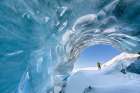 Man On Cross Country Skis Peers Into Entrance Of Glacier Ice Cave In Alaska Range, Interior, Alaska. Art Print