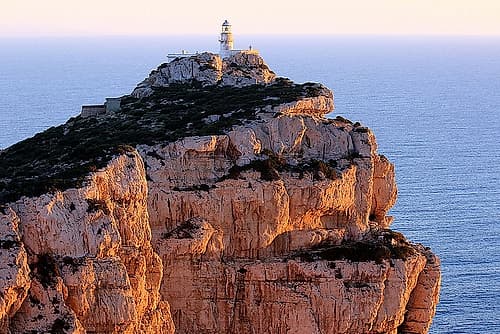 Peaceful Lighthouse on the cliff at sunset Art Print by Saiu Giovanni