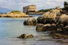 Saracen Tower on crystalline Sea with rocks Art Print