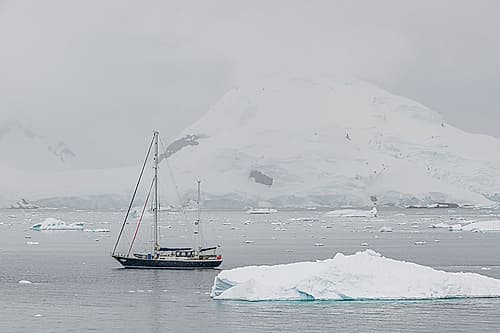 Sailboat Below Antarctic Mountain Art Print