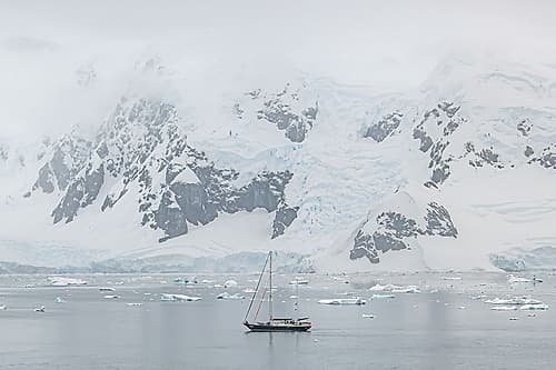 Sailboat Beneath Snowcapped Peaks Art Print