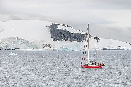 Red Sailboat Near Dark Rock Outcrop Art Print