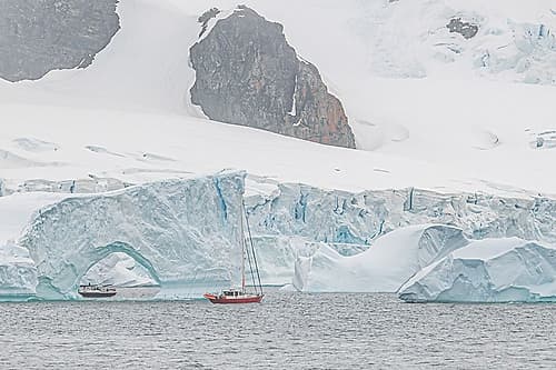 Two Sailboats Near Iceberg Arch Art Print