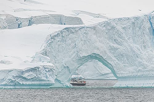 Expedition Boat Through Iceberg Arch Art Print