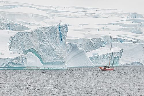 Red Sailboat Eroded Iceberg Formation Art Print
