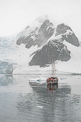 Sailboat Beneath Jagged Peak Vertical Art Print